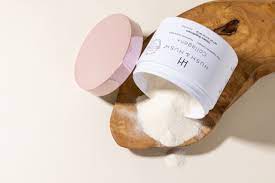 Ein umgefallenes Kosmetikprodukt mit weißem Pulver auf einem Holzbrett.