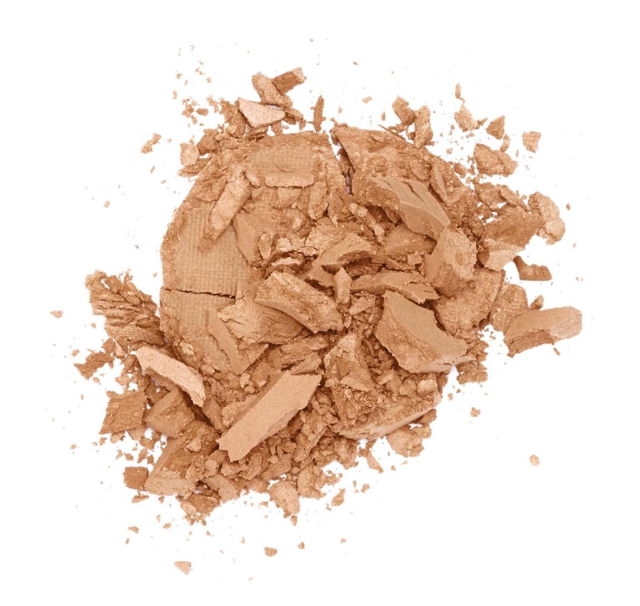 Zerbrochener, beiger Puder auf weißem Hintergrund.