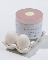 Hush & Hush Collagen+ Creme in rosa Dose, präsentiert auf weißem Eierhalter mit zwei Eiern.