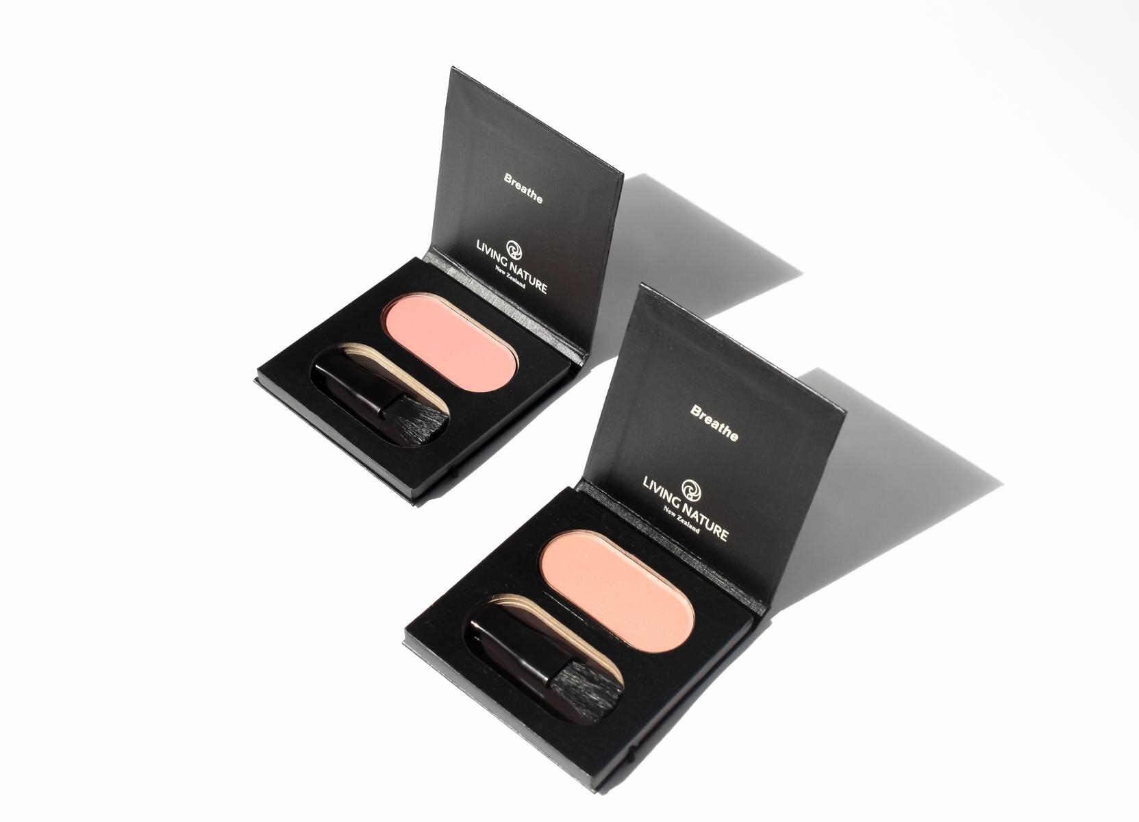 image_104358_3 Zwei geöffnete Make-up-Paletten mit Rouge und Pinsel auf weißem Hintergrund.