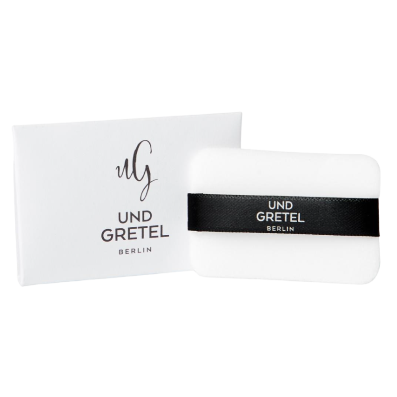 UND GRETEL ILGE Translucent Compact Powder Puff vor weißem Hintergrund, mit schwarzem Band und Verpackung.