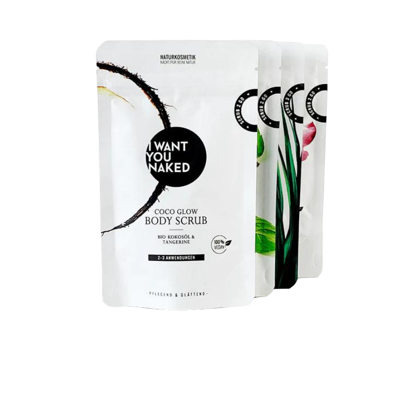 Paradise-in-a-Box-PhotoRoom-PhotoRoom Vier Packungen Naturkosmetik von 'I Want You Naked', darunter ein Body Scrub mit Bio-Kokosöl und Mandarine.