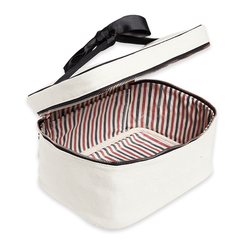 bag-all-beauty-box-klein-ohne-schrift-natur_2_optimized Geöffnete weiße Kosmetiktasche mit gestreiftem Innenfutter und schwarzem Reißverschluss.